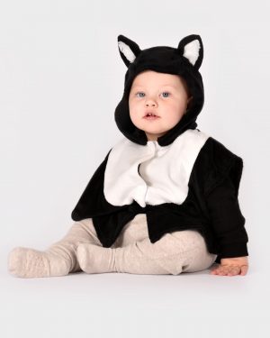 sittande barn som bär en svartvit kattdräkt med huva med fastsydda öron.