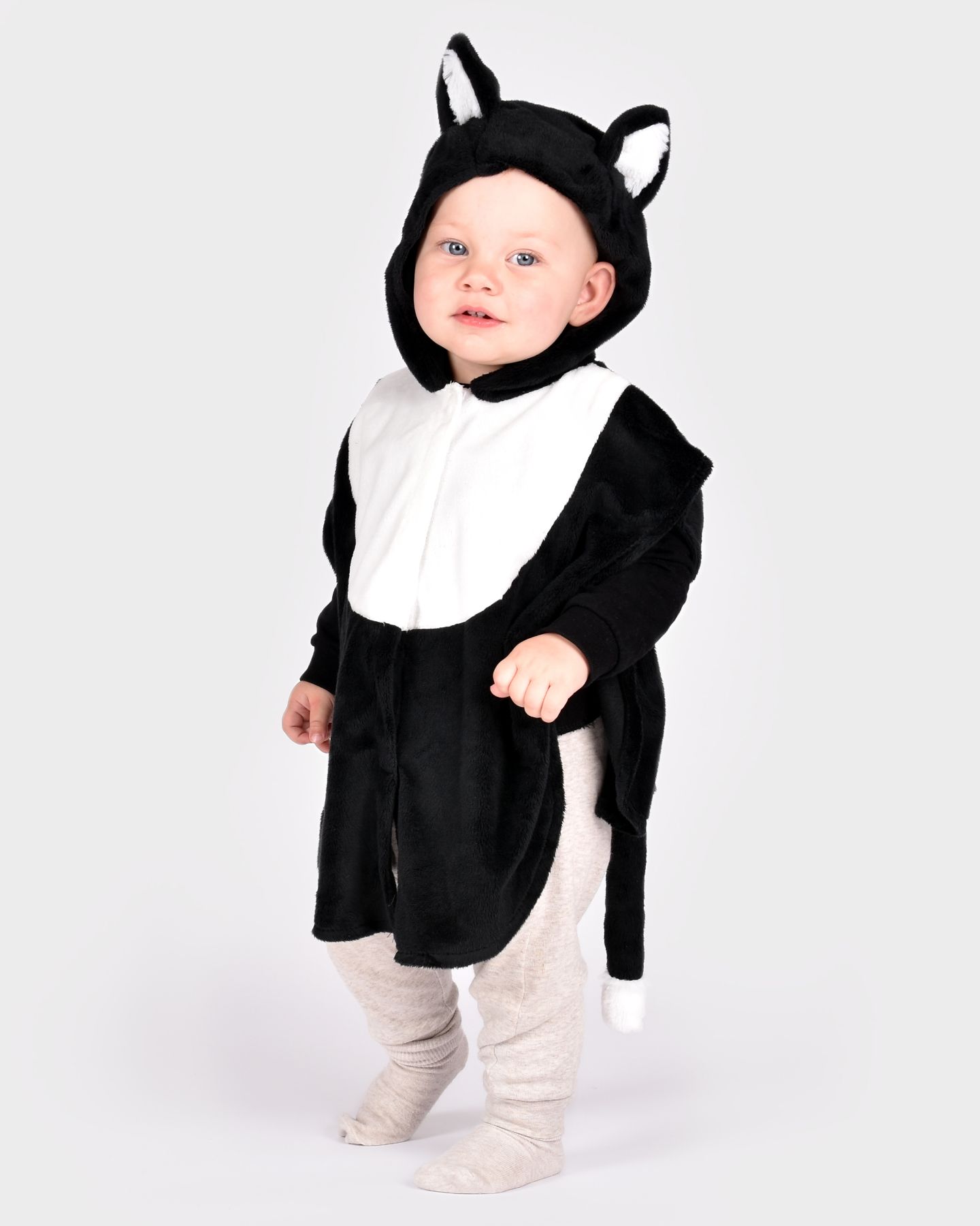 barn som bär en svartvit kattdräkt med vadderad svans samt huva med fastsydda öron.