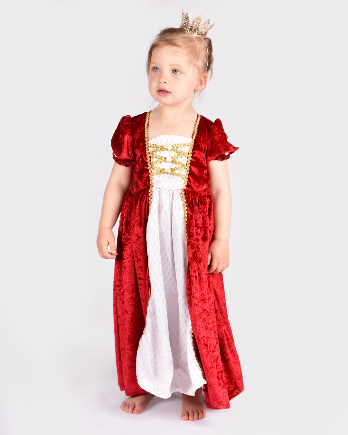 Flicka iklädd en röd prinsessklänning och guldig prinsesskrona