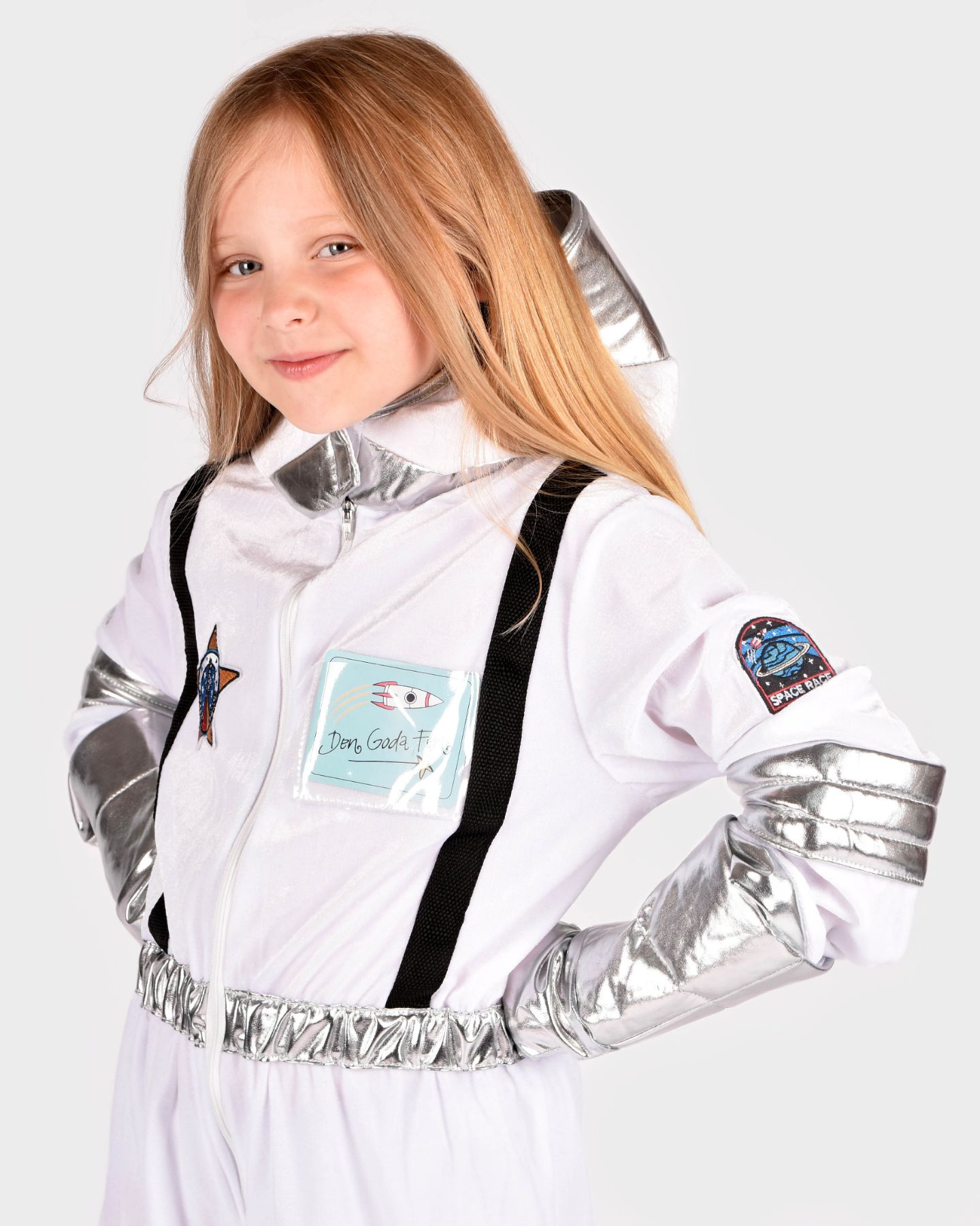 Flicka som bär en vit astronautdräkt med svarta och silvriga detaljer