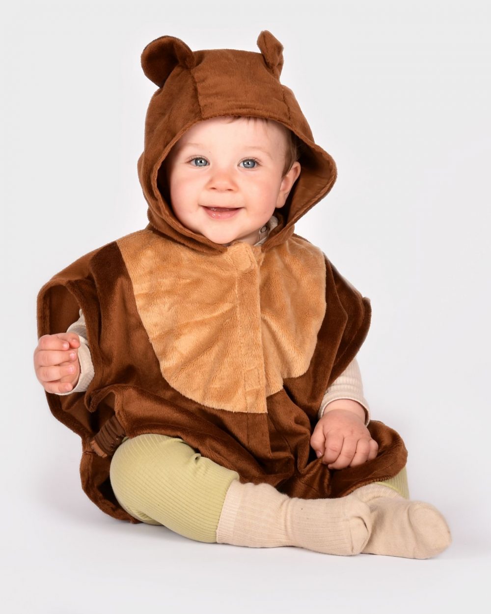 sittande barn som bär en brun björncape med huva med fastsydda öron.
