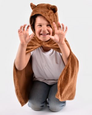 Barn iklädd en brun björncape. Capen har en huva med två öron.