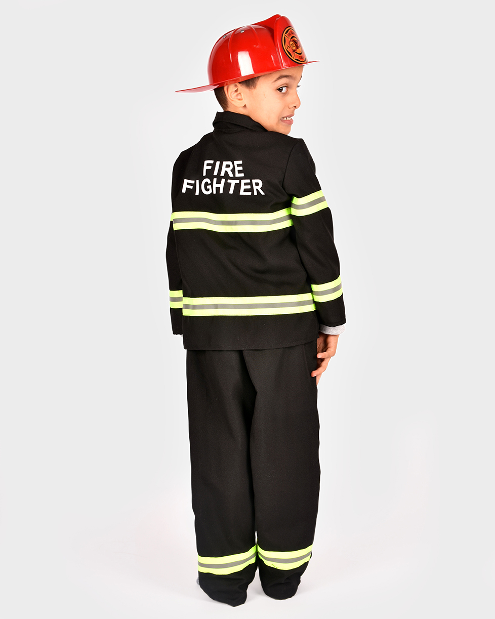 pojke tittar över axeln iklädd en svart brandmansdräkt och röd brandmanshjälm