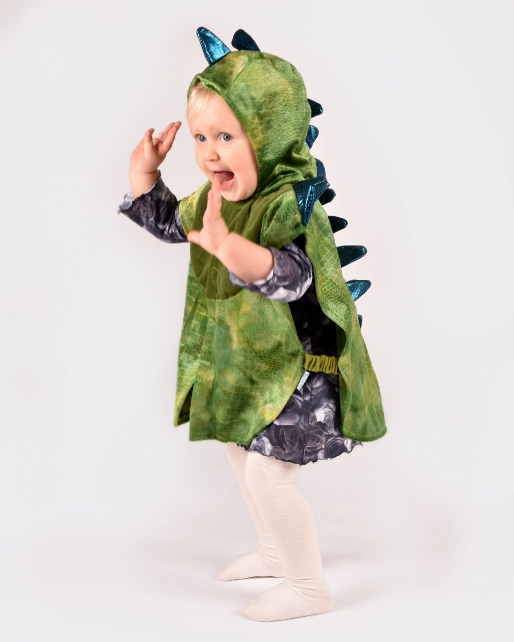 barn iklädd grön drakdräkt med blå taggar