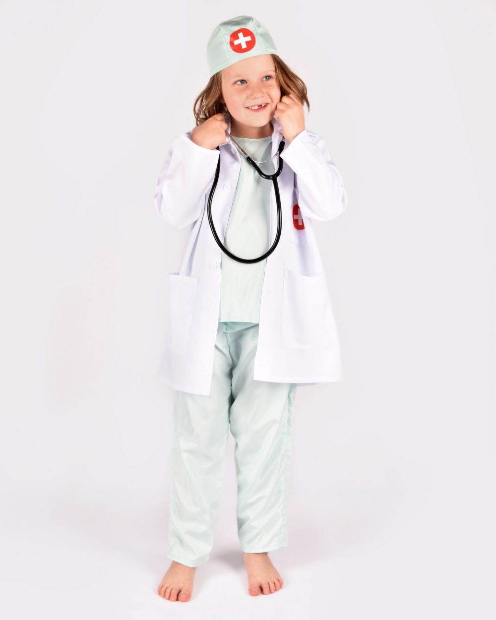Flicka som bär en grönvit doktorsdräkt och ett svart stetoskop.