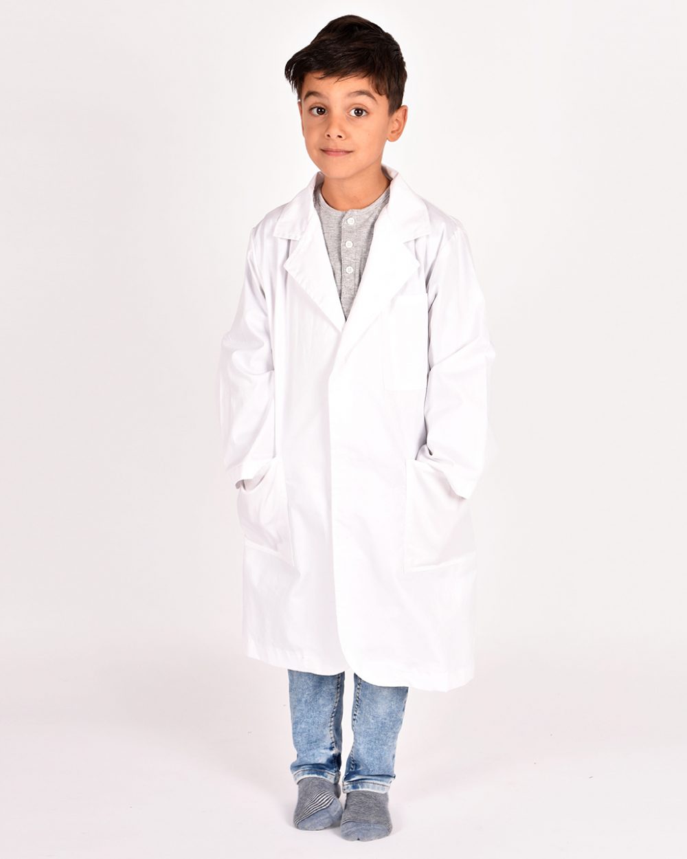 pojke i vit labbrock/doktorsrock med händerna i fickorna