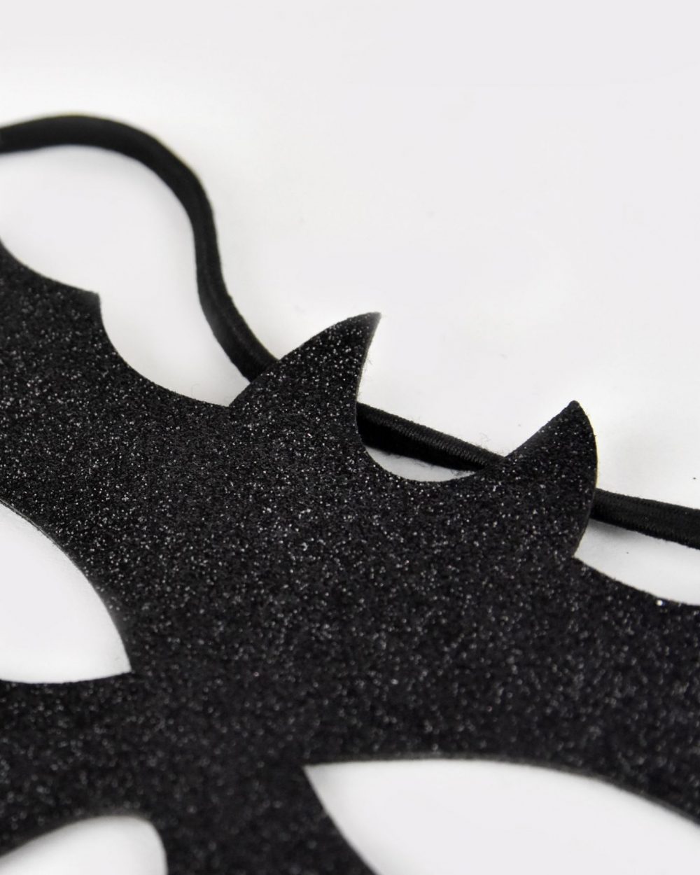 Närbild på en svart glittrig batmanmask.