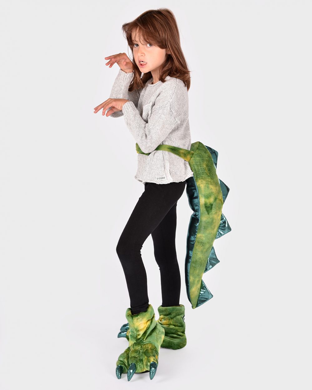 flicka iklädd grön dinosauriesvans samt matchande mystofflor