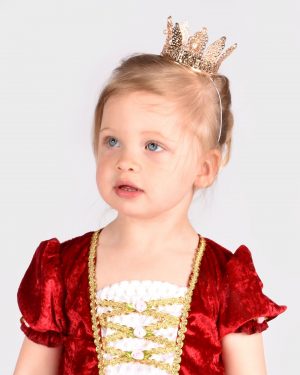 Flicka som bär en guldig metallkrona och en röd prinsessklänning.