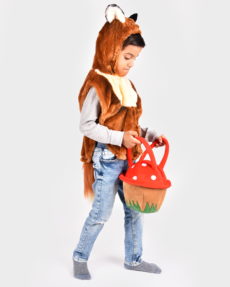 Pojke iklädd en brun rävcape bär en väska i form av en flugsvamp