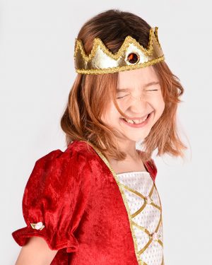 glad flicka som bär en guldig kungakrona och en röd prinsessklänning