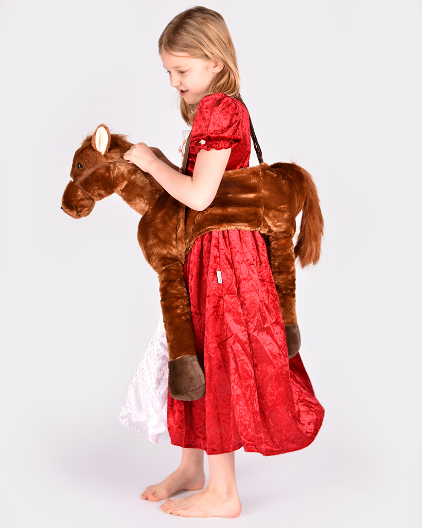 flicka iklädd röd prinsessklänning och brun hästrideon